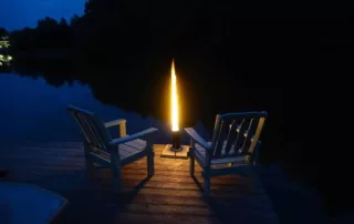 Gemütliches Ambiente am See mit Stühlen und einem Feuerrohr / Pelletfackel